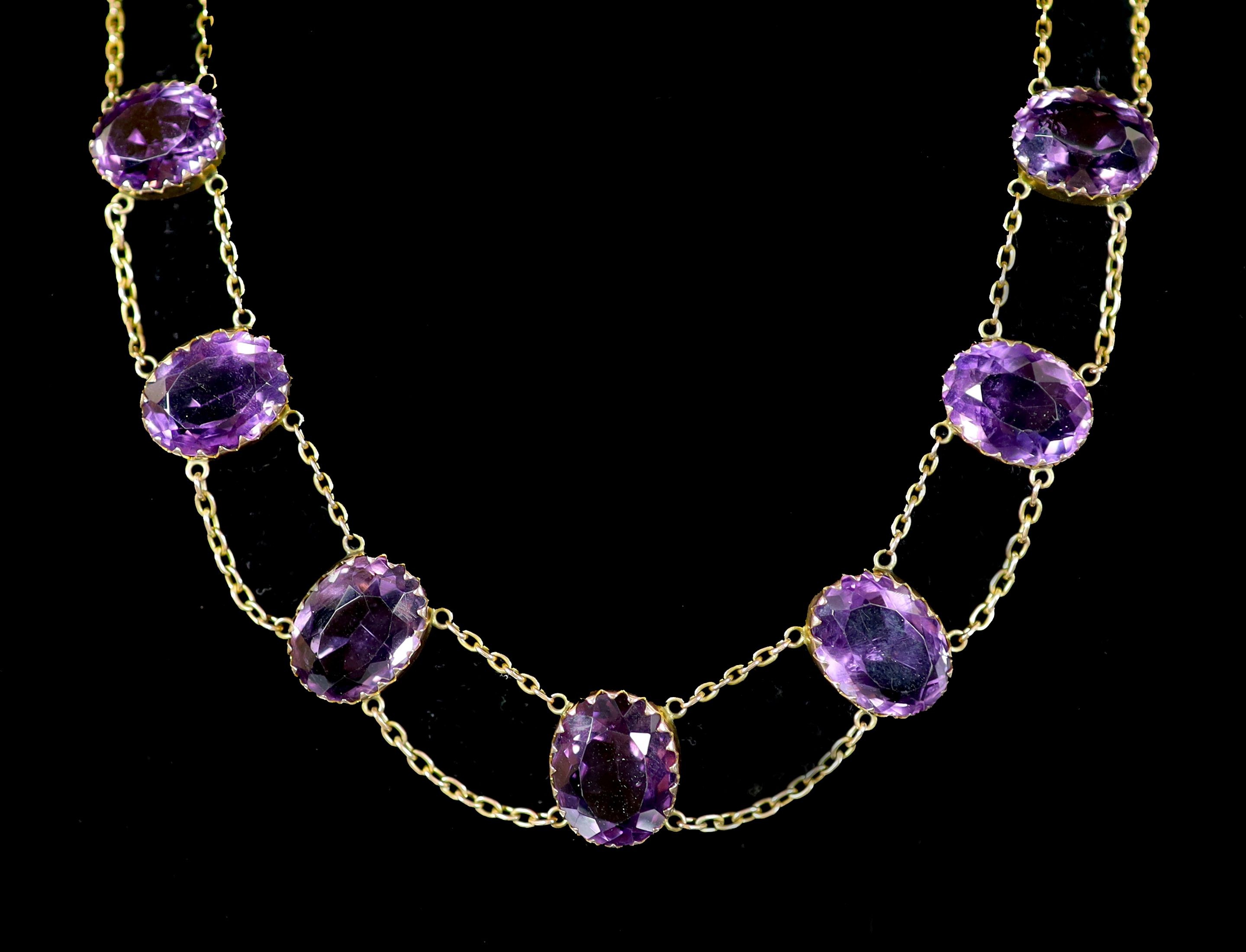 An Edwardian 9ct gold and graduated oval cut amethyst riviere necklace
